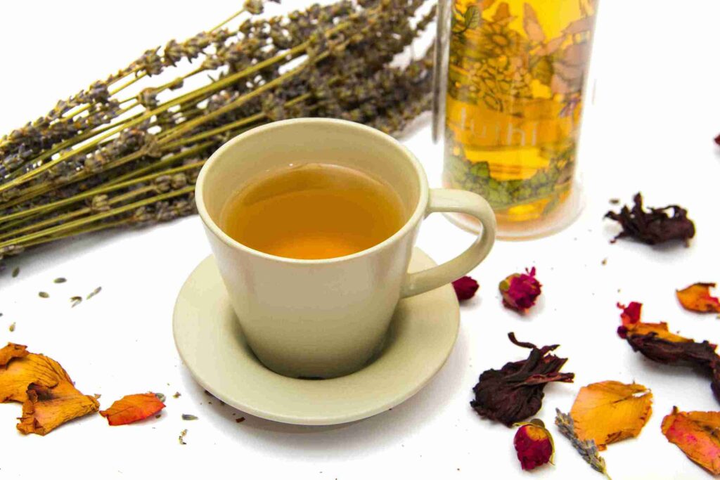 Secangkir teh herbal di antara bunga kering, untuk meluruskan mitos minuman herbal dan menjelaskan fakta sebenarnya