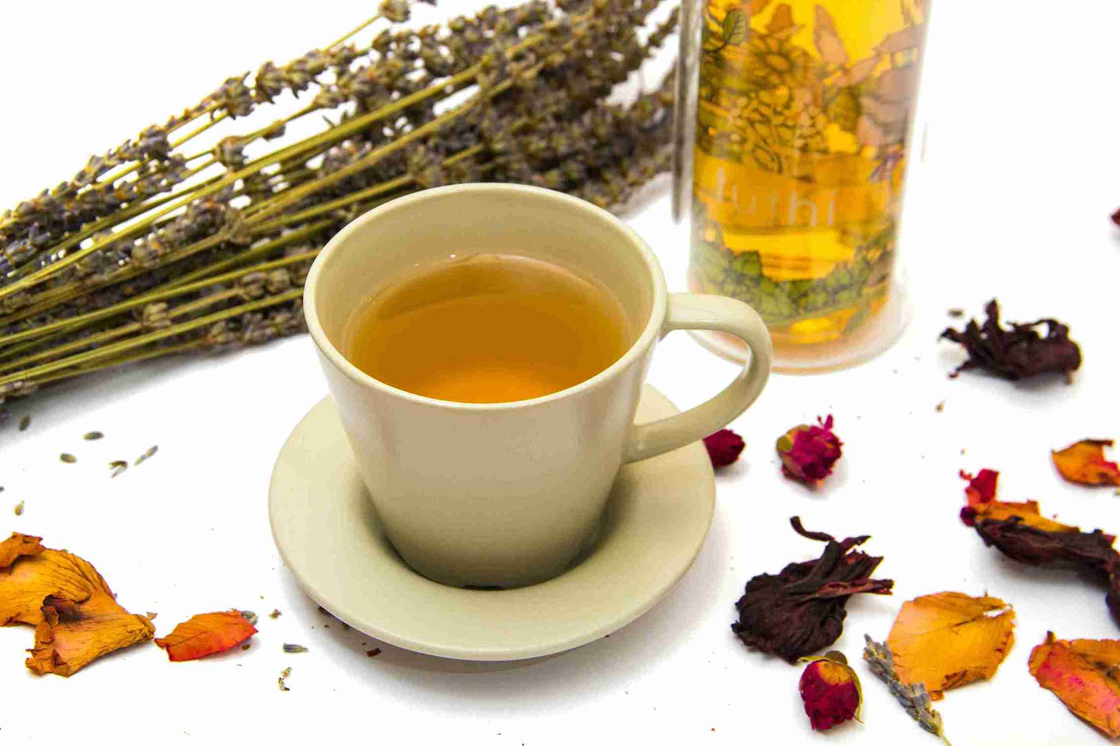Secangkir teh herbal di antara bunga kering, untuk meluruskan mitos minuman herbal dan menjelaskan fakta sebenarnya