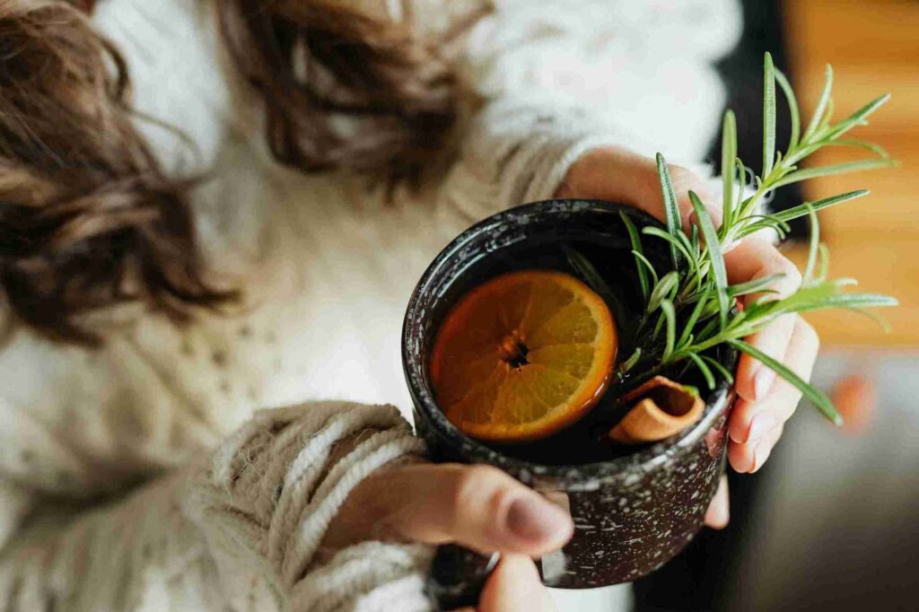 Seseorang memegang secangkir minuman herbal hangat, menunjukkan pentingnya mengetahui mitos minuman herbal sebelum mengonsumsi