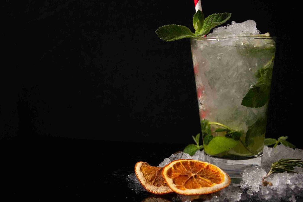 Segelas minuman dingin dengan irisan jeruk nipis kering dan daun mint, salah satu cara menikmati manfaat jeruk nipis.
