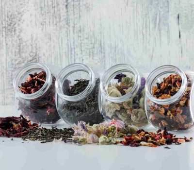 Empat toples berisi aneka rempah dan simplisia kering, menunjukkan pentingnya cara menyimpan rempah yang benar untuk setiap jenis