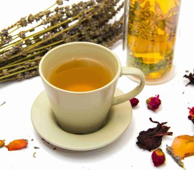 Secangkir teh herbal di antara bunga kering, untuk meluruskan mitos minuman herbal dan menjelaskan fakta sebenarnya